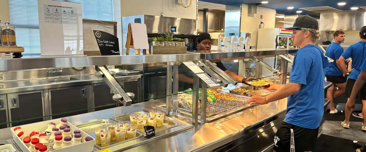 Student being served in dining hall line